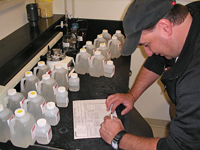 Chris Wilhelm completes Chain of Custody forms for water samples prior to shipping to the laboratory.